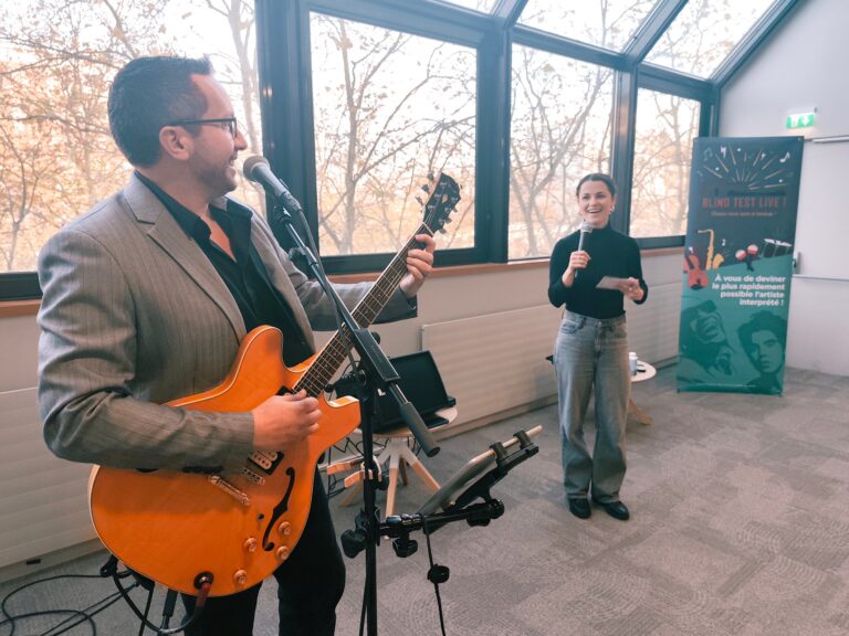 Un musicien et l'animatrice Julie qui animent le blind test handicap dans une entreprise