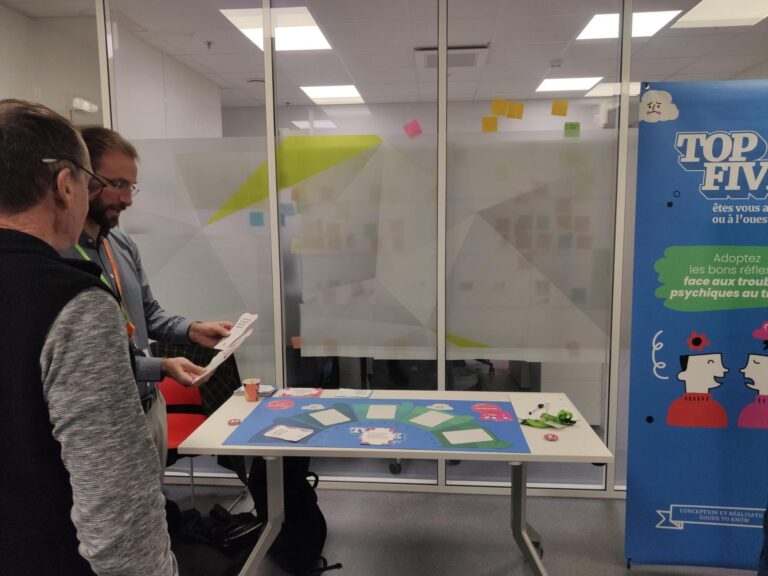 2 salariés jouent à Top Five, l'animation sur la santé mentale, ils lisent le contenu des cartes Réaction