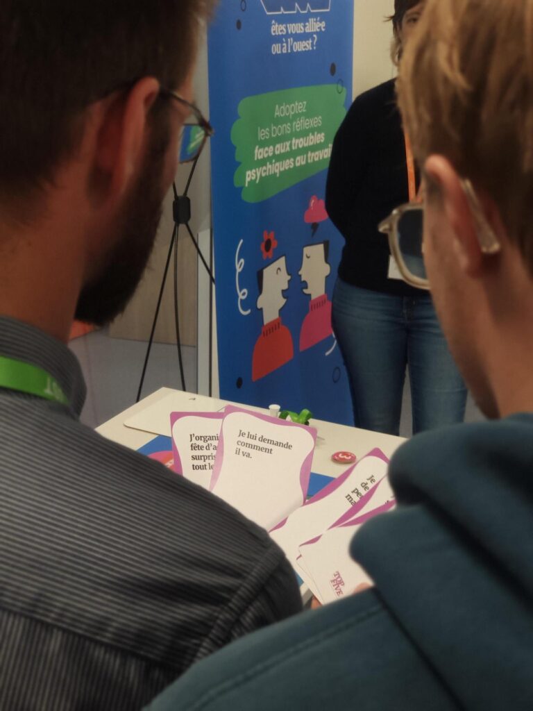 2 salariés jouent à Top Five, l'animation sur la santé mentale, ils lisent le contenu des cartes Réaction