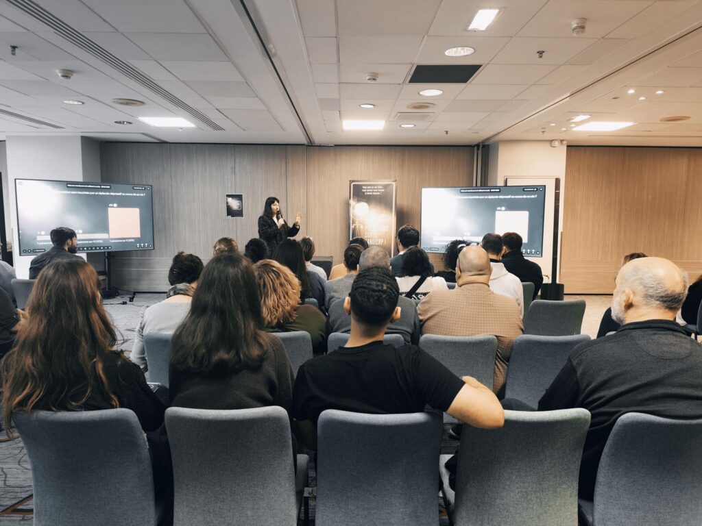 Animation Ciné Quiz, des salariés écoutent l'animatrice Mathilde en train de parler dans une grande salle